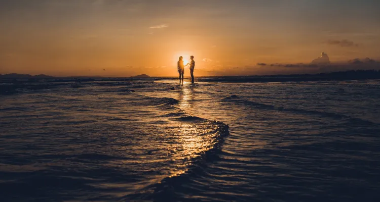 海の浅瀬を歩くカップル